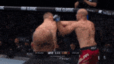 two men are fighting in a boxing ring with true classic on the side of the fence