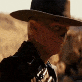 a man wearing a cowboy hat with a skull on his face