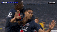 a soccer player wearing a qatar airways jersey is being hugged by another player