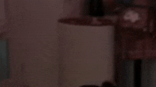 a blurred image of a person standing in a dark room holding a umbrella .