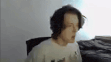 a man wearing headphones is sitting in front of a computer .