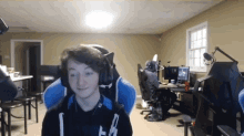 a boy wearing headphones is sitting in a blue chair in a room