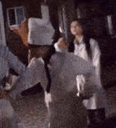 a man in a chef 's hat is dancing with a woman in a lab coat .
