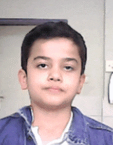 a young boy wearing a blue jacket and white shirt