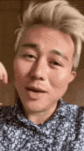 a man with blonde hair is wearing a blue and white shirt