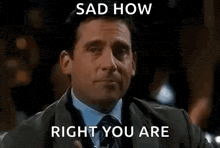 a man in a suit and tie is holding a glass of water and pointing at it .