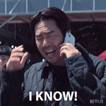 a man talking on a cell phone with the words " i know " below him