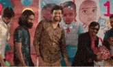 a group of men are standing in front of a picture of a baby