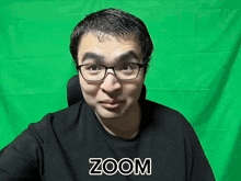 a man wearing glasses and a black shirt with the word zoom on it