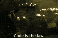 a man talking on a cell phone with the words code is the law written below him