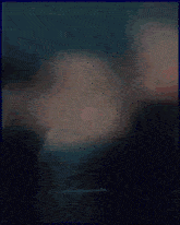 a blurry picture of a woman in a black top with her eyes closed