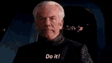 a man is sitting in a chair and says `` do it ! ''
