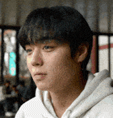 a close up of a man 's face with a white hoodie on