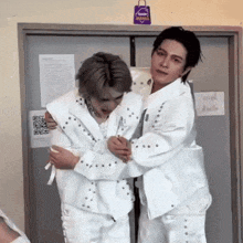 two men hugging each other in front of a sign that says sweet mama on it