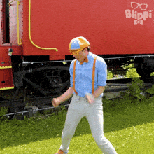 a man standing in front of a red blippi train