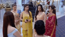 a group of women are standing in a circle in a room .