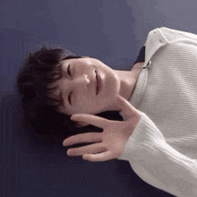 a person is laying on their stomach with their hands outstretched and smiling .