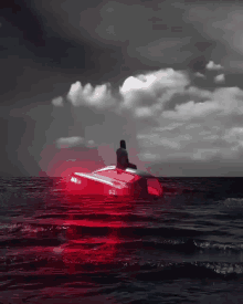 a man sits in a red boat that says ma on the back