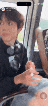 a person sitting in a car with a phone that says nextide