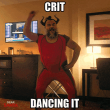 a man in a devil costume is dancing in front of a tv with the words crit dancing it below him