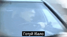 a man is driving a car with a sign that says gotyi ibalo on it