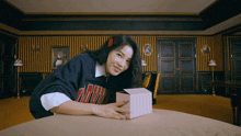 a woman wearing a sweater that says arizona is laying on a table