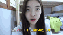 a young girl is standing in front of a bunk bed and talking to the camera .