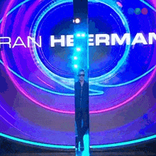 a man is standing in front of a sign that says rain heerman