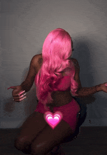 a woman with pink hair is kneeling down with a pink heart on her stomach