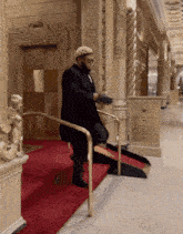a man in a black coat is walking down a ramp