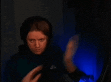 a man wearing headphones is sitting in front of a computer screen and making a funny face .