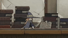 a cartoon witch is standing next to a stack of books .