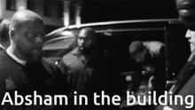 a black and white photo of a group of men with the caption absham in the building
