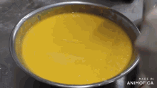 a close up of a bowl of yellow liquid that says made in animatica