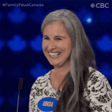 a woman with gray hair is smiling while wearing a name tag that says lucia
