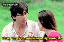 a man and a woman are talking to each other in a park .