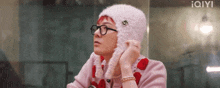 a person wearing glasses and a pink hat with a g on it