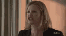 a woman is making a funny face while looking out of a window .