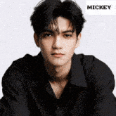 a young man in a black shirt with the name mickey on the bottom right