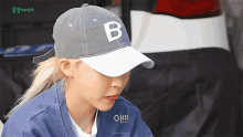 a woman wearing a baseball cap with a letter b on it