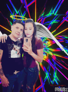 a man and a woman are posing for a picture with a colorful background by tony lopez