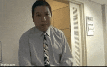 a man in a suit and tie is standing in a hallway .