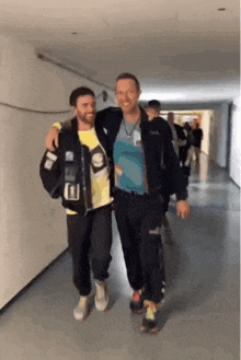two men standing next to each other in a hallway with one wearing a shirt that says ' i love you '