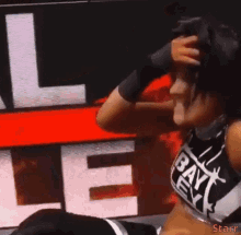 a woman wearing a black top that says bayley