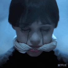 a close up of a person 's face with a netflix logo on the bottom right