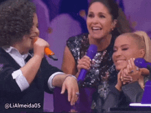 a purple microphone is being held by a woman with the hashtag lialmeida05 on the bottom