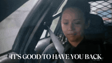 a woman is sitting in a car with the words it 's good to have you back
