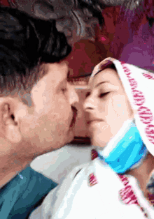 a man and woman are kissing and the woman is wearing a head scarf that says ' i love you ' on it