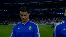 a man wearing a blue adidas shirt smiles