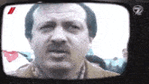a man with a mustache is shown on a tv screen with the number 7 on it